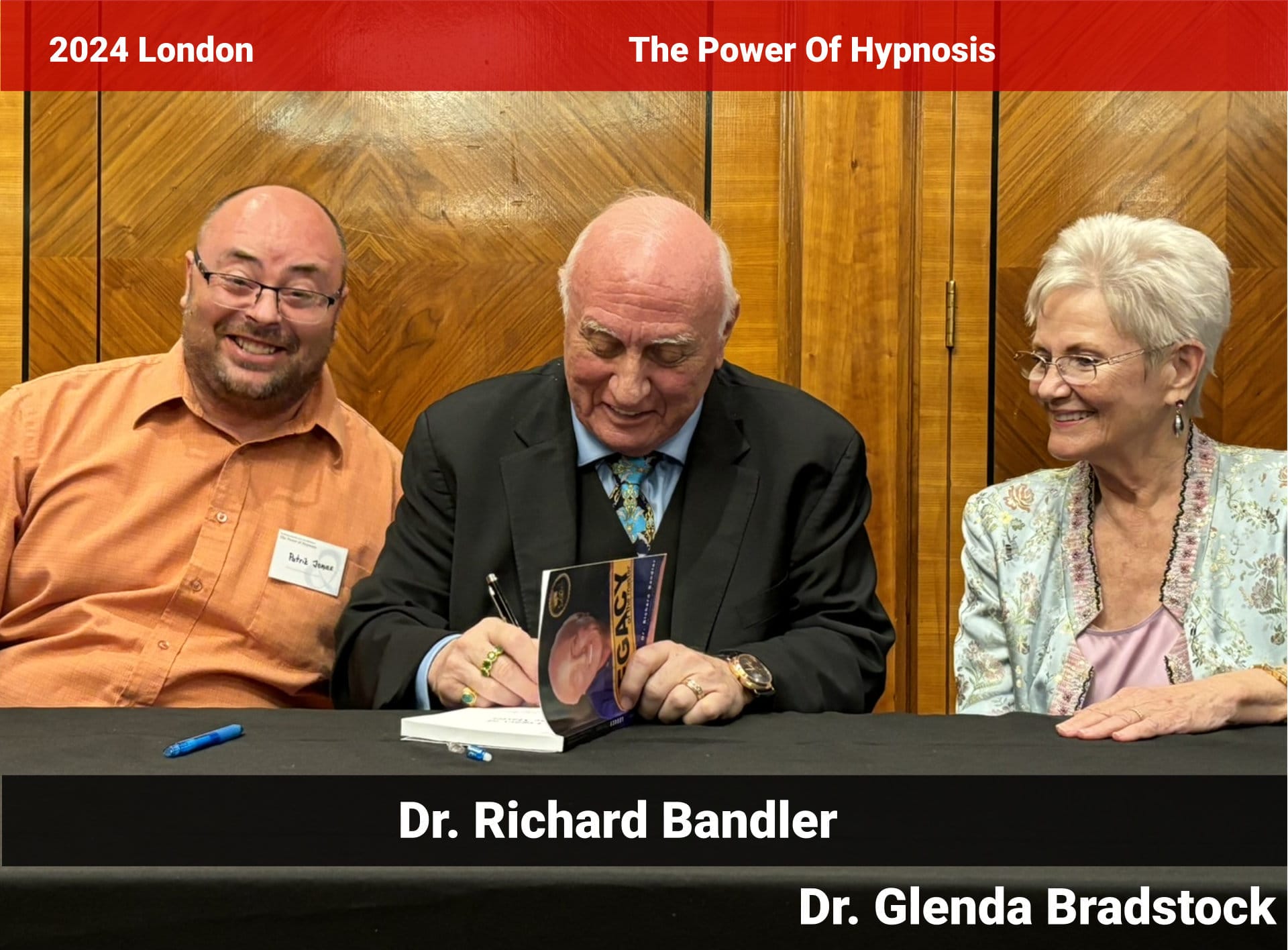 Fotografie Patrik Jonáš, Dr Richard Bandler, Glenda Bradstock, Dr Bandler píše podpis a věnování do své knihy Legacy